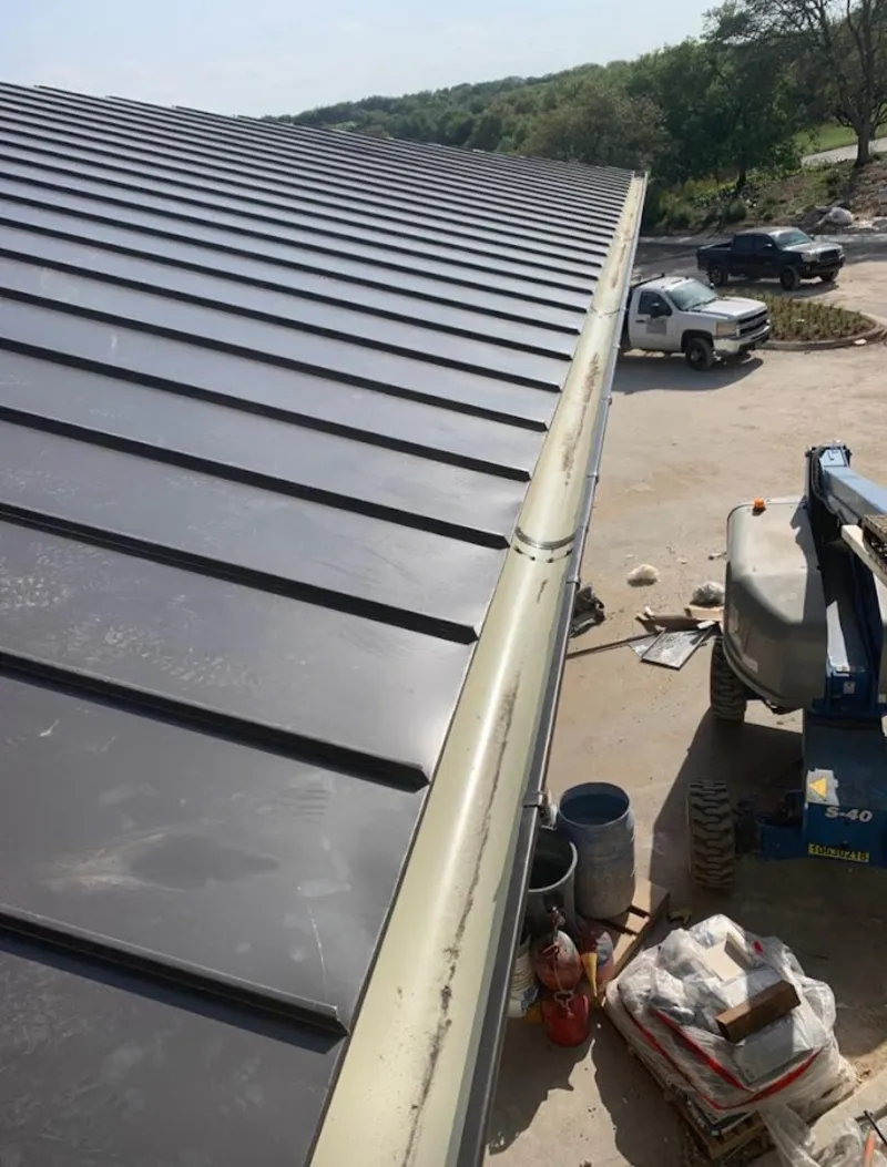 Standing seam panel and gutter detail on a metal roofing jobsite in Bath